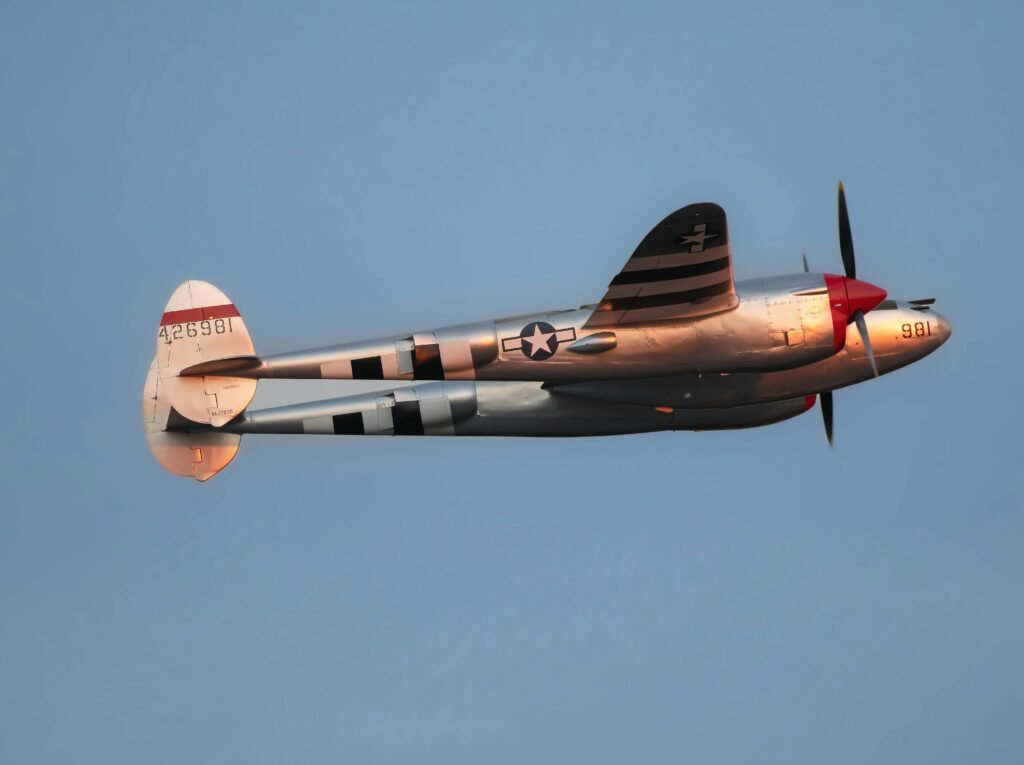 Classic vintage military aircraft flying in clear blue sky showcasing aviation history.
